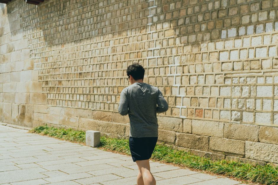 야외에서 골전도 이어폰을 착용하고 조깅하는 사람.